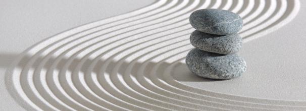 Zen garden with three stacked stones and racked sand