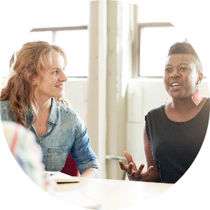 Two women talk to each other in a meeting